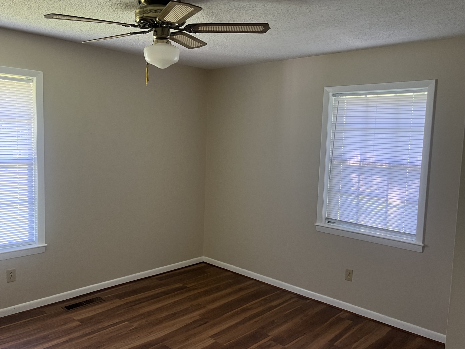 Bedroom with neutral walls and wood-look flooring